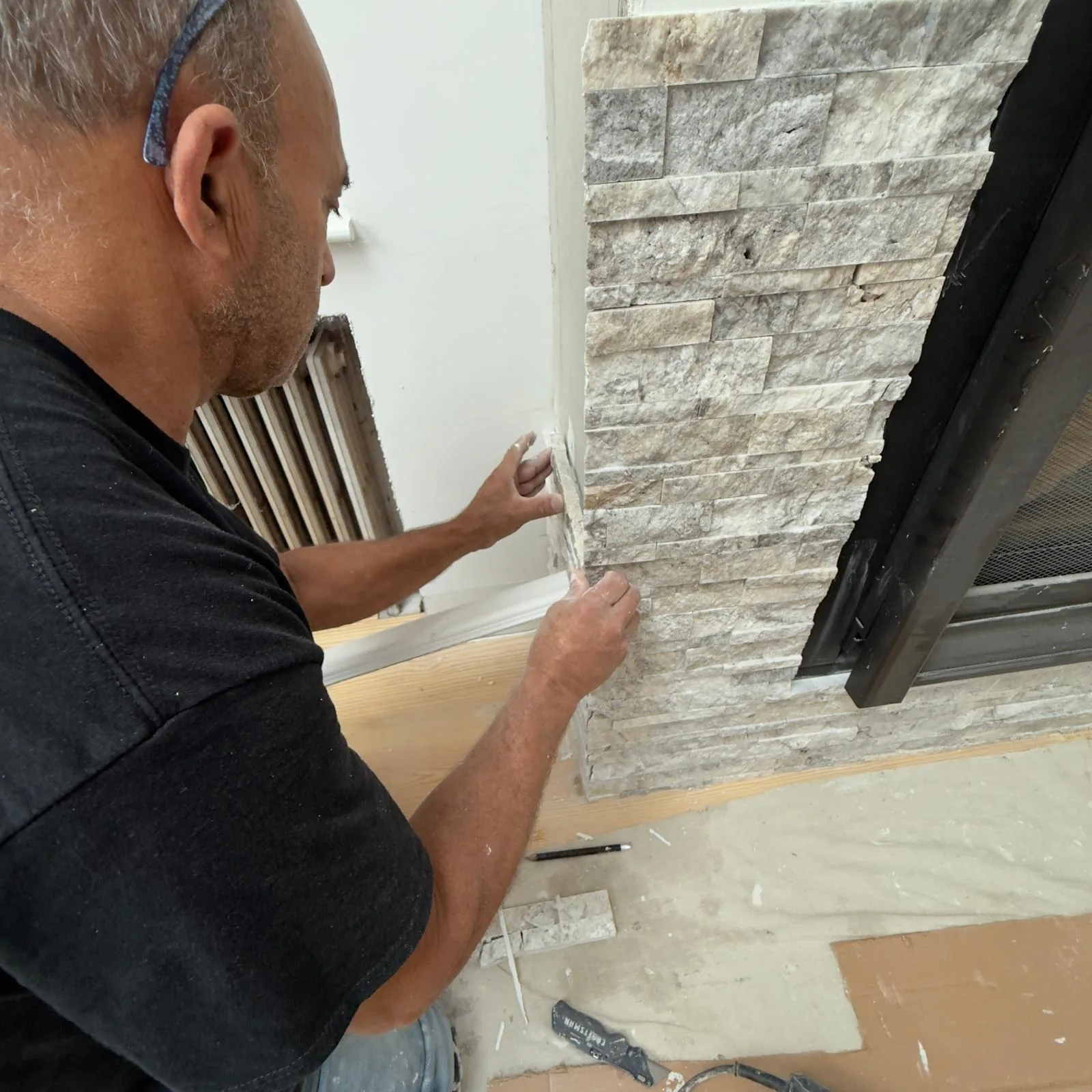 CRC craftsman fitting stone veneer around a fireplace
